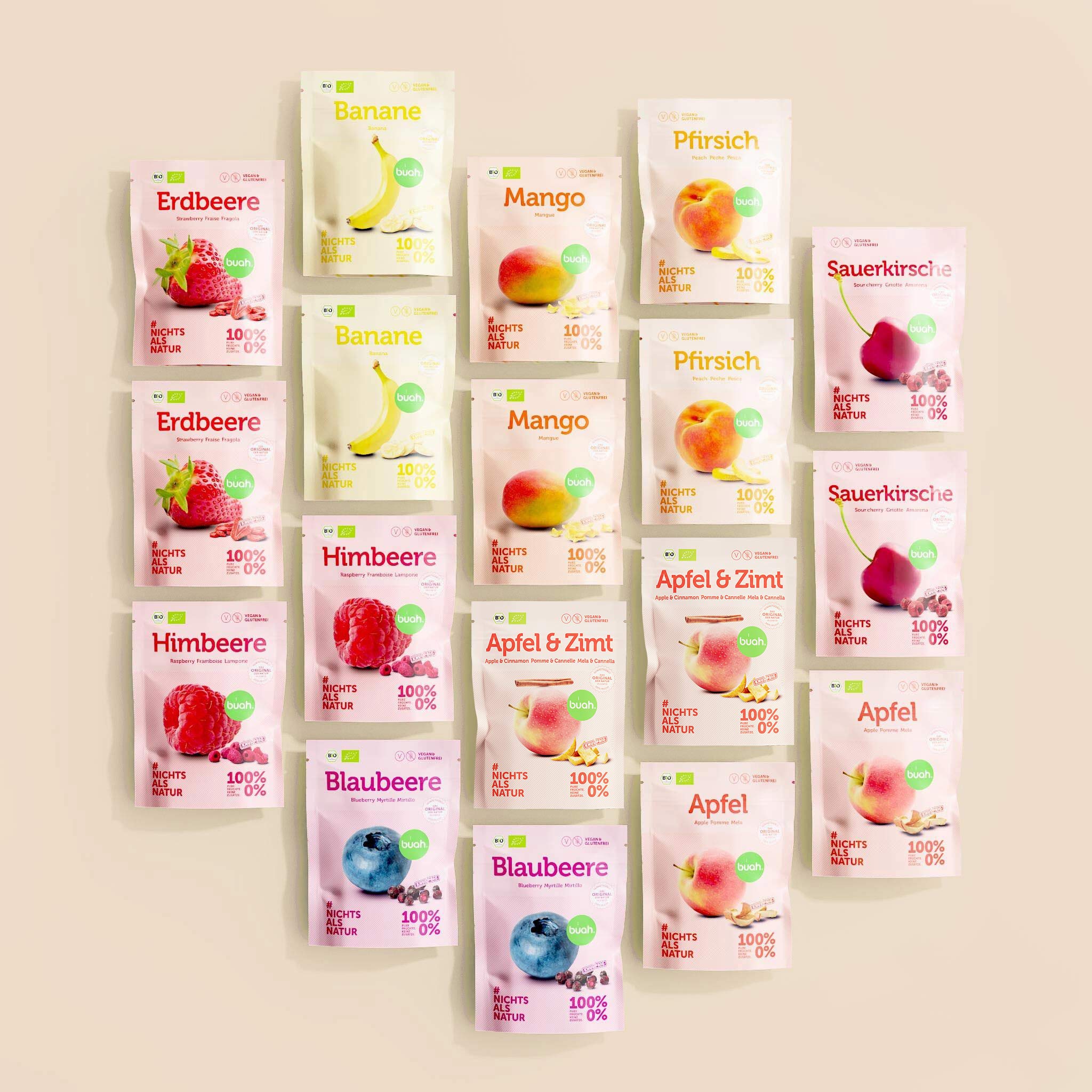 Set aus diversen buah Snackpack in verschiedenen Sorten, Erdbeere, Frucht & Nussmischung, Mango, Pfirsich, Sauerkirsche, Himbeere, Blaubeere, Ananas und Apfel - Snackpacks liegen nebeneinander aus Vogelperspektive, Hintergrund in beige. 